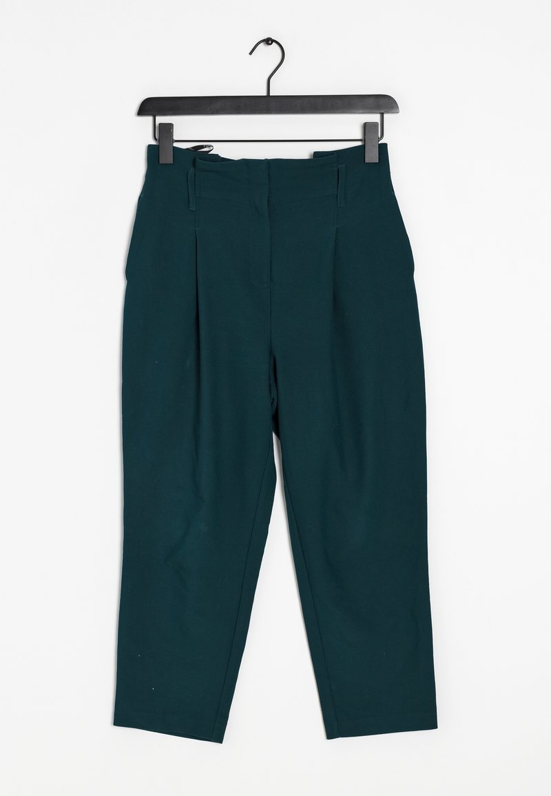 Teal high-waisted trousers with pleats, featuring a smooth texture and cropped length, hanging on a black clip hanger.
