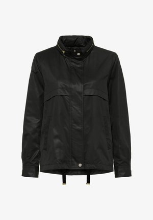 Czarna wodoodporna kurtka z wysokim kołnierzem, zapinana na zamek z przodu, z dwiema kieszeniami na piersiach. Posiada elastyczne sznurki ściągające na dole i przy mankietach.