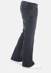Vaqueros de mezclilla oscura con corte recto, cinco bolsillos y un parche de cuero negro en la cintura. Diseño limpio y minimalista, adecuado para el uso informal.