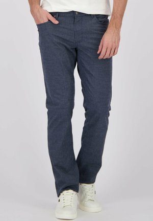 Donkerblauwe herenbroek van lichtgewicht stof, met een klassiek vijf-pocket ontwerp en rechte pijpen, gecombineerd met witte sneakers.