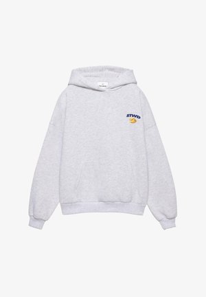 Svetlosivá mikina s kapucňou a predným vreckom, malým nápisom "STWD" a grafikou šišky na šťastie na ľavej strane hrude, s kapucňou so šnúrkami.