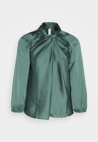 Blouse verte en satin à manches longues, col haut et détail plissé à l'avant. Dotée de poignets élastiques et d'une ouverture en forme de goutte dans le dos.