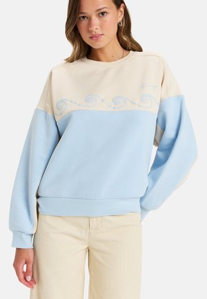 Sudadera azul claro y beis con bordado de olas en el pecho, puños acanalados, corte relajado y material de algodón suave.