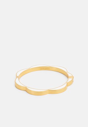Gold bangle bracelet with white enamel petals forming a scalloped flower shape, engraved with brand name inside.