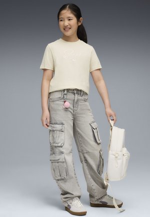 Ljusgul t-shirt med kort ärm och vit logotyp, grå cargobyxor med fickor och beige sneakers. Ryggsäcken är off-white med en enkel design.