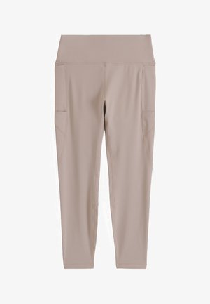 Beige high-waist leggings with side pockets, smooth fabric, and fitted ankle-length design.
