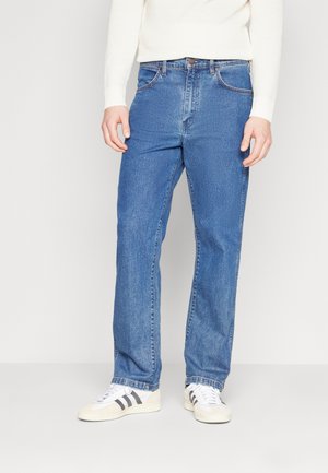 Blå denim jeans med lige pasform, fem-lomme design og en lys vask. Har en brun knappelukning og subtile sydetaljer.