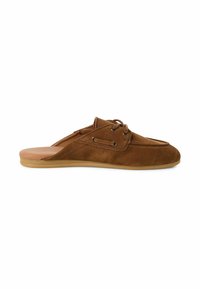 Chaussure à enfiler en suède marron avec un bout arrondi, un détail de laçage et une semelle en caoutchouc claire. Texture lisse avec des accents de couture subtils.