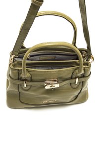 Bolso verde con relieve de cocodrilo, herrajes dorados, doble asa y una correa desmontable. Cuenta con interior a rayas y compartimentos con cremallera.