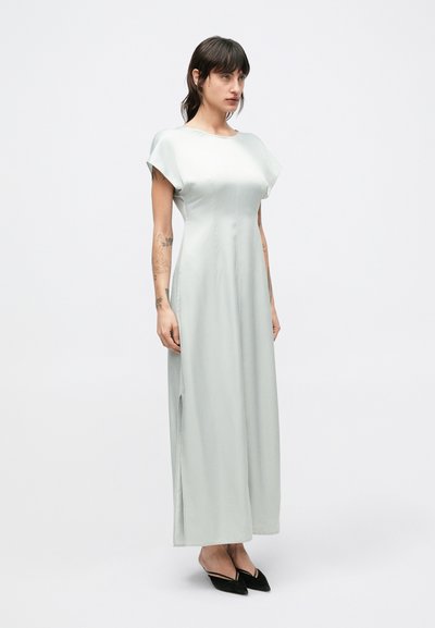 Saténové, svetlozelené dlhé šaty s krátkymi rukávmi, so bočným rozparkom a hladkou, elegantnou líniou.