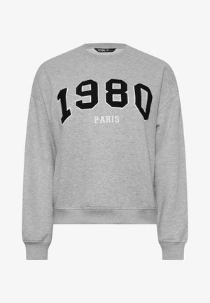 Sweatshirt gris en tissu doux, avec un col rond, des manches longues et un texte brodé noir "1980 PARIS" en lettres capitales.