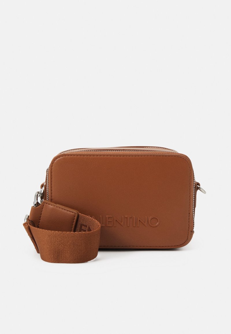 Brown leather crossbody bag with a rectangular shape, featuring a zip closure and a strap with a logo detail. Smooth texture.