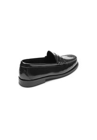 Mocasín de charol negro con detalle cosido y ligero tacón, que presenta una superficie lisa y brillante y una silueta clásica.