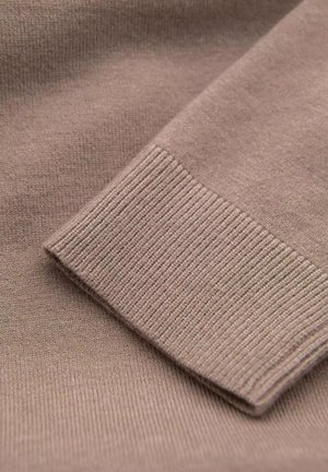 Tejido marrón de punto con una superficie suave y textura acanalada en el puño, mostrando un borde doblado para un acabado limpio.