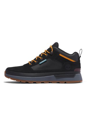 Czarno-szary niskoprofilowy sneaker z pomarańczowymi sznurowadłami, uchwytem na pięcie oraz brązową gumową podeszwą.