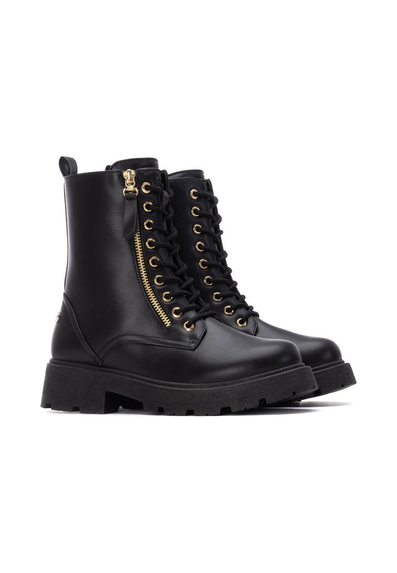 Bottines en cuir noir avec une semelle épaisse, des détails en or, un laçage frontal et une fermeture éclair sur le côté pour un accès facile.