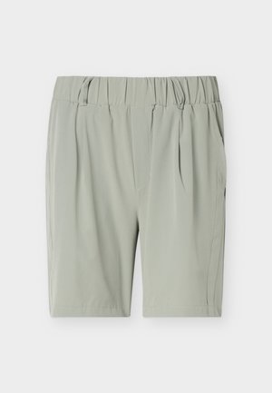 Pantaloni scurți gri deschis cu talie elastică, cu bretele pentru curea și buzunare laterale, fotografiați pe un fundal alb simplu.