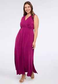 Maxi sukienka w intensywnym magentowym kolorze, z zawiązywanym przodem, bezrękawowym kroju i bocznymi rozcięciami. W zestawie z jasnymi, strapami na obcasach.
