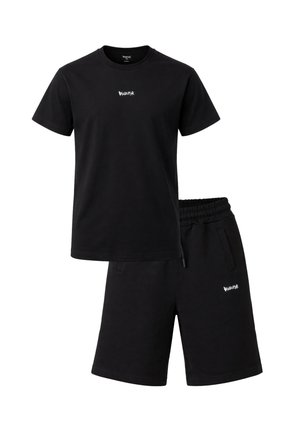 Set composto da T-shirt nera a maniche corte e pantaloncini al ginocchio con piccoli loghi grafici bianchi sul petto e sulla coscia sinistra, fascia elastica in vita sui pantaloncini.