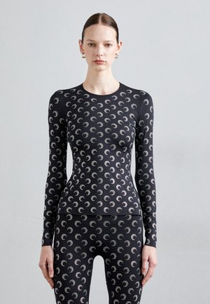 Black long-sleeve athletic top featuring a repeating crescent moon pattern in silver. The fabric appears smooth and form-fitting.