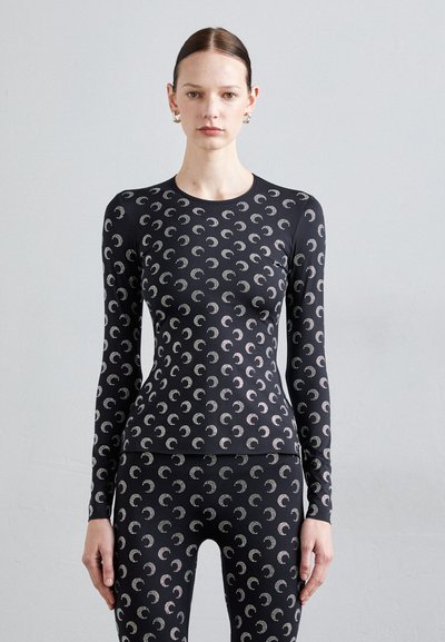 Sort langærmet træningstrøje med et gentagende mønster af halvmåner i sølv. Stoffet ser glat og tætsiddende ud.