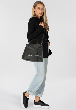 Sac en cuir noir avec surface texturée, doté de deux anses et d'une bandoulière amovible. Logo "DENIM TOM TAILOR" en blanc.