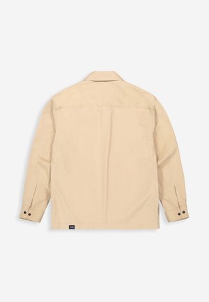 Beige jack met lange mouwen, knoopmanchetten en een klein zwart label onderaan de zoom, gezien van achteren tegen een witte achtergrond.