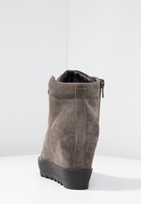 Stivale alla caviglia in suede grigio con tacco a zeppa, cerniera laterale e suola in gomma testurizzata. Dettaglio di cucitura lungo il retro e fodera interna liscia.