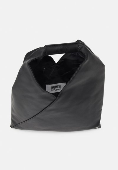 Bolsa de couro preta com um design envolvente único, apresentando uma alça curva e uma etiqueta interna. Textura suave e estilo minimalista.