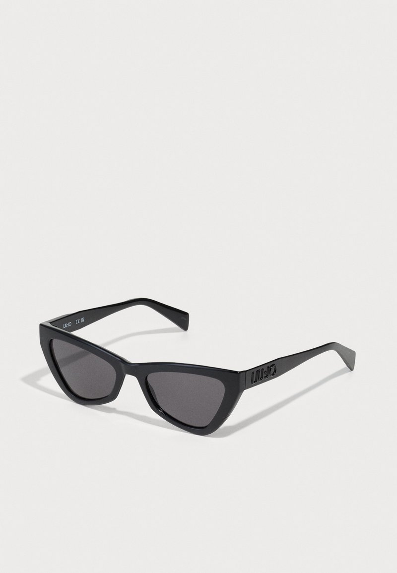Schwarze Cat-Eye-Sonnenbrillen mit dunklen Gläsern, leichtem Kunststoffrahmen, kantigem Design und geprägtem Logo am seitlichen Bügel.