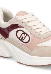 Zapatillas con una mezcla de beige y rosa, con acentos de charol burdeos, gamuza texturizada y una suela blanca gruesa. Incluye detalles del logo en el lateral.
