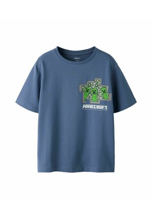 Blå T-shirt med korte ærmer og Minecraft-design, der viser tre grønne pixel-creeper-figurer og Minecraft-logoet på brystet.