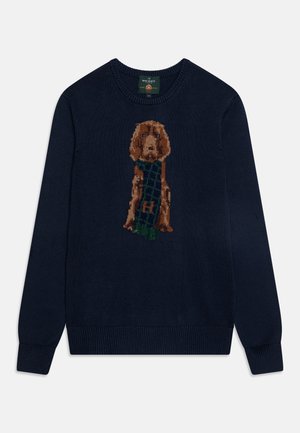 Granatowy dzianinowy sweter z brązowym psem noszącym zielono-granatowy szalik w kratę na środku przodu.