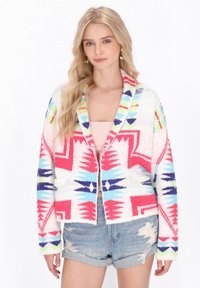 Fuzzy oversize kofta i vitt med rosa, blå och gröna geometriska m�önster; öppen framsidan, långa ärmar och fickor.