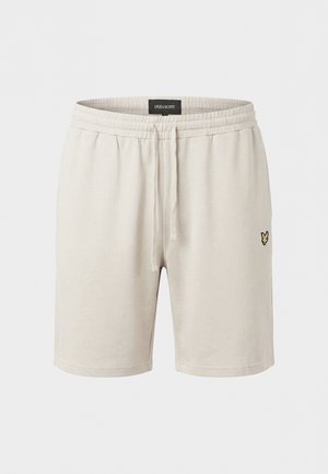 Lys beige bomullsshorts med elastisk midje, snøring og liten svart og gullfarget brodert fuglelogo på venstre lår.