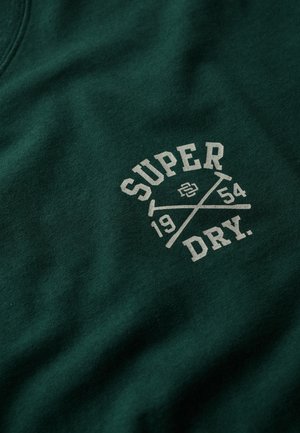 Groene katoenen sweatshirt met een centrale print van de woorden "SUPER DRY," het jaartal "1954," en gekruiste accenten in een lichtere kleur.