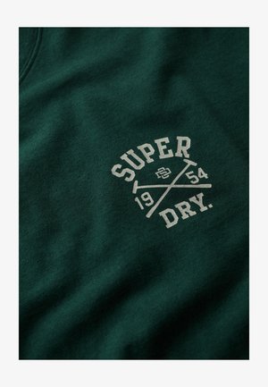 Groene katoenen sweatshirt met een centrale print van de woorden "SUPER DRY," het jaartal "1954," en gekruiste accenten in een lichtere kleur.