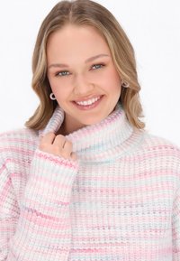 Maglione a collo alto lavorato a maglia con una sensazione morbida e strutturata, caratterizzato da righe rosa e bianche e un design comodo e morbido.
