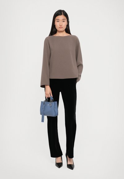 Brown long-sleeve top, black velvet pants, and a small blue handbag. Black pointed-toe heels. Simple, streamlined design.