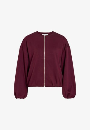 Bordeauxrote Jacke mit Reißverschluss, rundem Ausschnitt, übergroßen Ärmeln und gerafftem Saum. Hergestellt aus weichem Stoff mit glatter Textur. Silbernes Reißverschlussdetail.