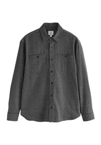 Camisa de manga larga a rayas blancas y negras con cuello abotonado, dos bolsillos en el pecho y tejido texturizado.