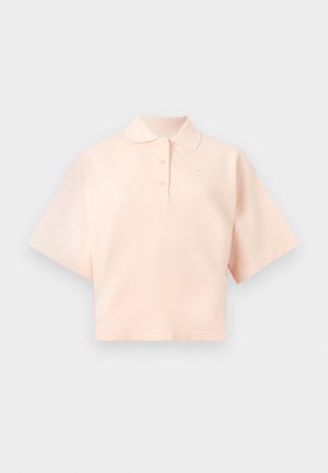 Polo corto en rosa claro con mangas cortas y anchas, tapeta con tres botones y pequeño logo bordado en el pecho.