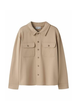 Veste-chemise beige à manches longues avec col, boutons sur le devant et deux poches poitrine boutonnées sur fond blanc.