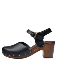 Zoccoli in pelle nera con tacco in legno, dotati di una cinghia e fibbia regolabile. I rivetti in argento decorativi lungo la base arricchiscono il design.