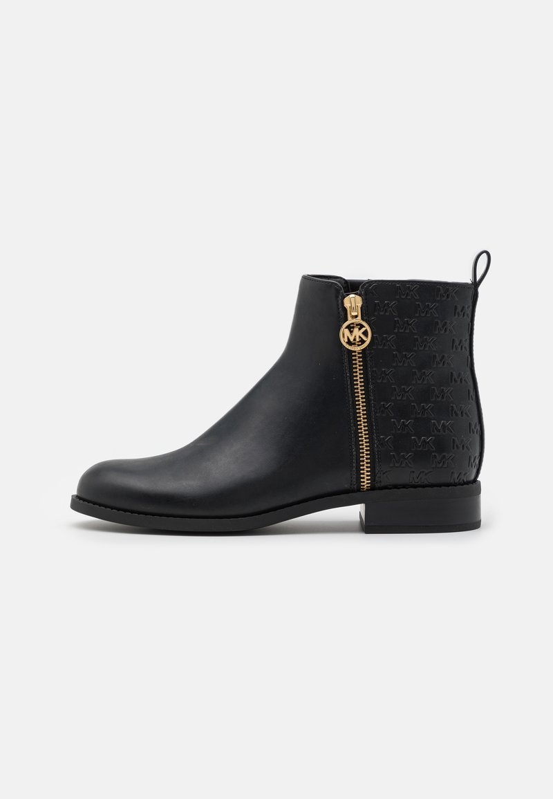 Bottine noire avec motif embossé à l'arrière, fermeture éclair dorée et tirette circulaire avec logo MK, et talon empilé bas.
