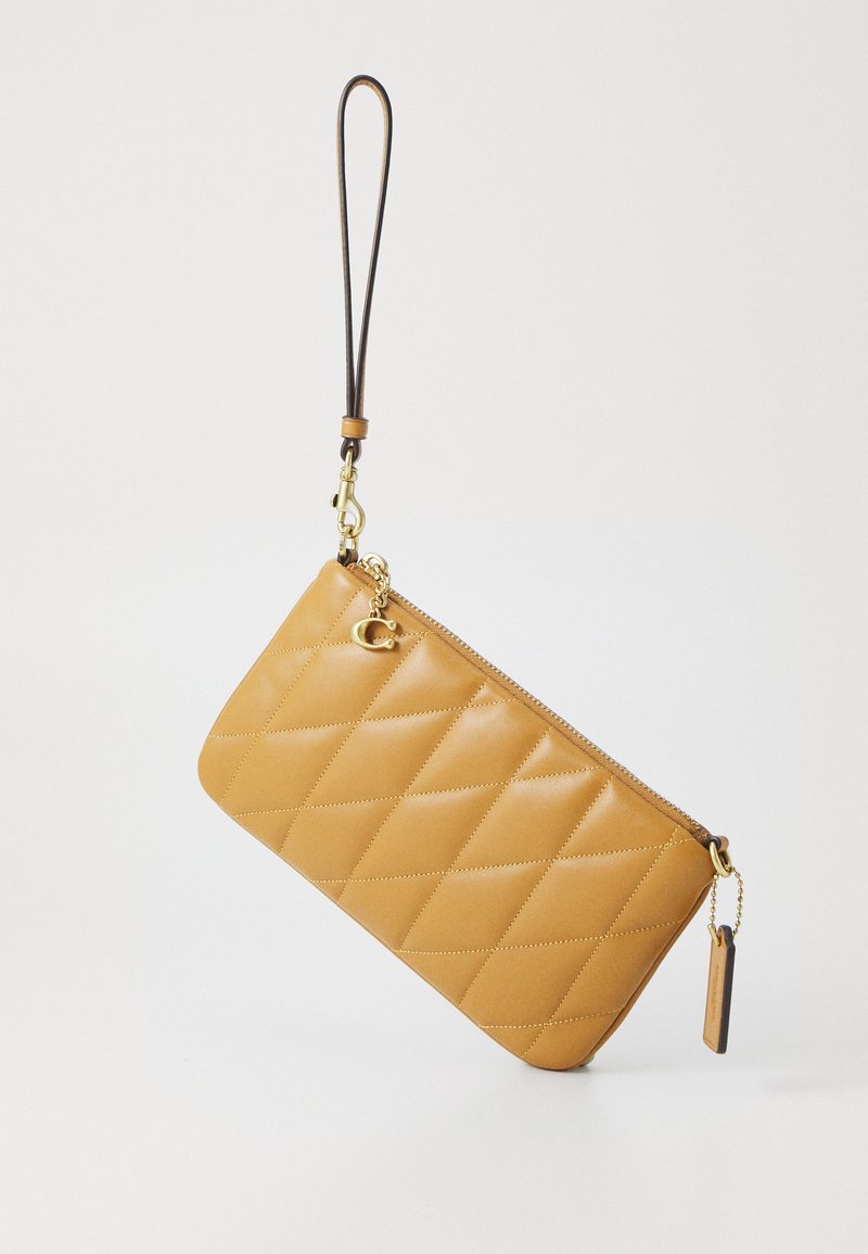 Gequilted gele leren clutch met een gouden rits, polsband en decoratieve charm. Heeft een gladde textuur en een rechthoekige vorm.