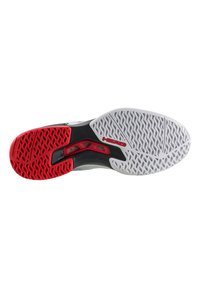 Die Schuhsohle verfügt über eine strukturierte weiße Gummiunterlage mit einem roten Gummibereich und schwarzen Akzenten, die für Traktion und Langlebigkeit ausgelegt ist.