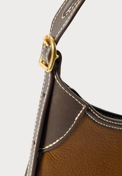 Bolsa de couro marrom com uma alça castanha escura. Apresenta um fecho de metal dourado e costura branca contrastante ao longo das bordas. Textura suave.