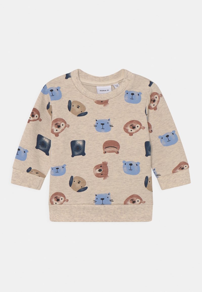 Sweat-shirt beige présentant un motif répété de divers visages d'animaux en bleu et marron. Tissu doux avec poignets et ourlet côtelés.