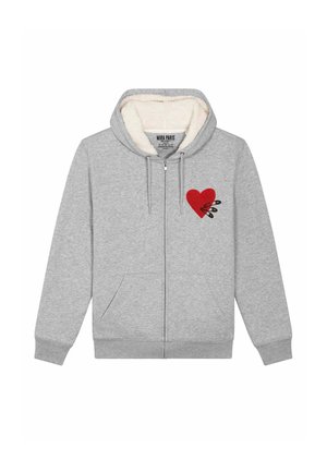 Grijze zip-up hoodie met een zachte witte binnenkant, met een rood hartontwerp en twee zwarte veiligheidsspeldjes op de linkerkant van de borst. Voorzakken aanwezig.